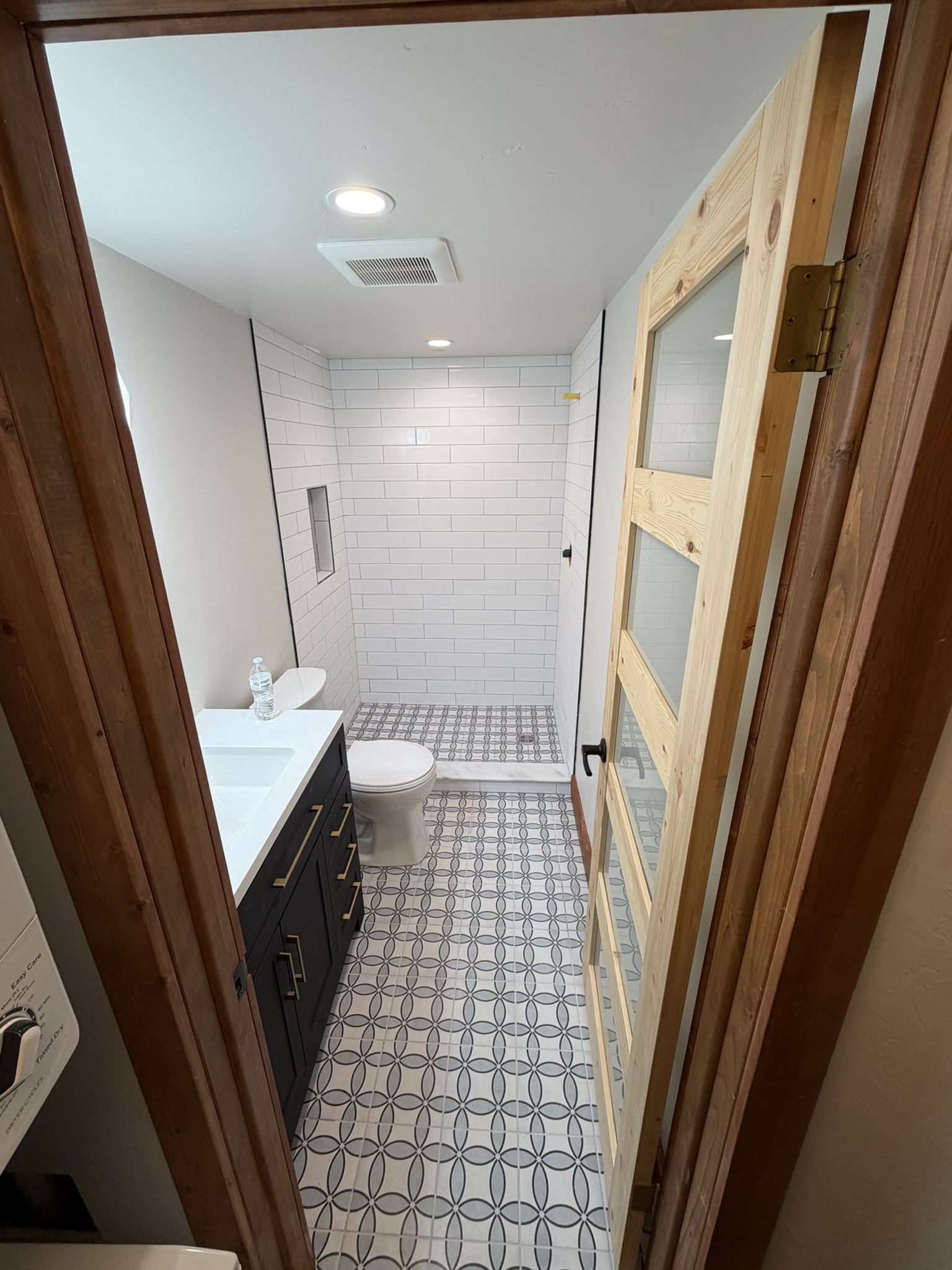 Finished bathroom with patterned tile floor and walk-in shower