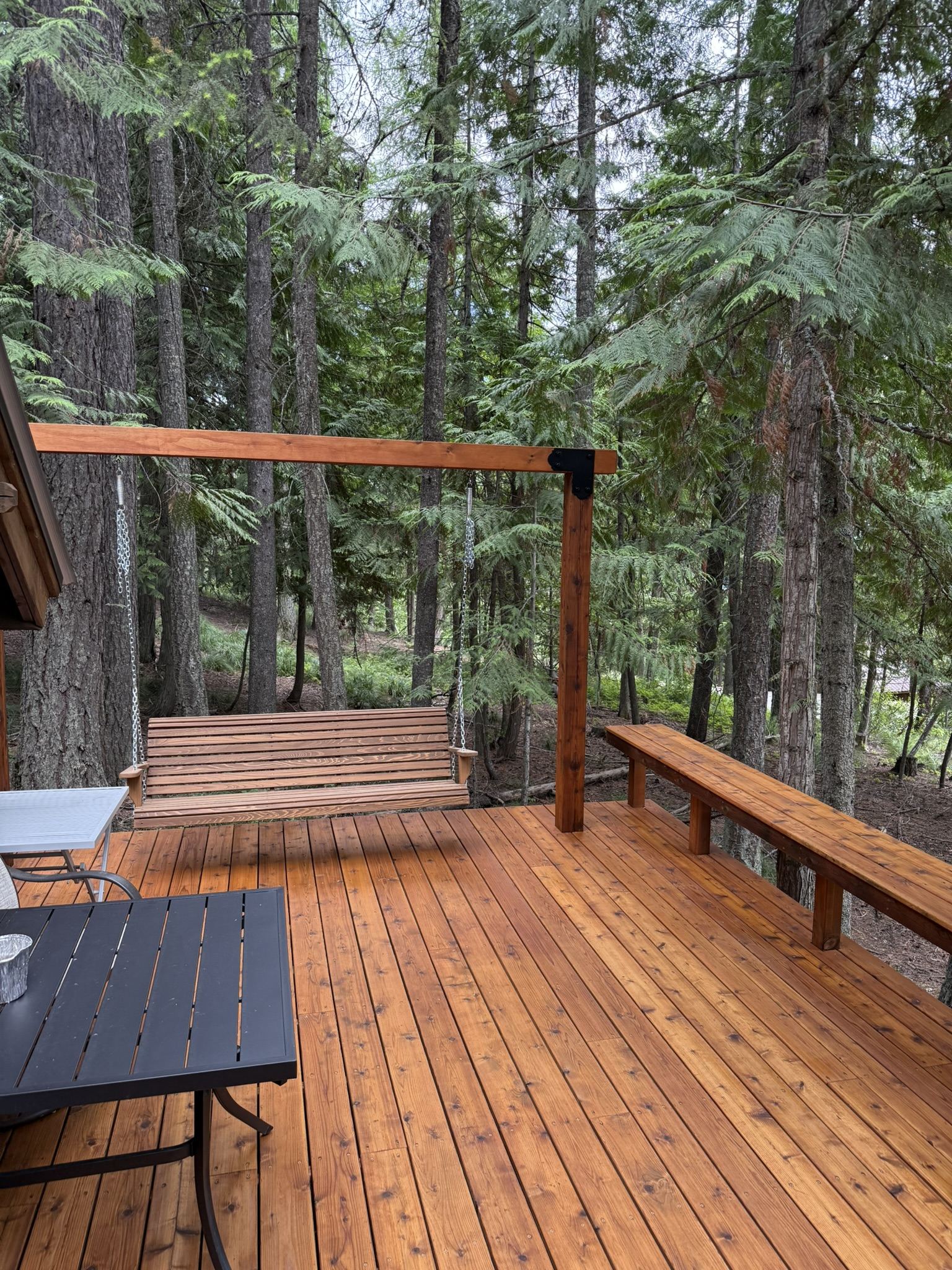 Cedar deck with built-in bench railing surrounded by pines