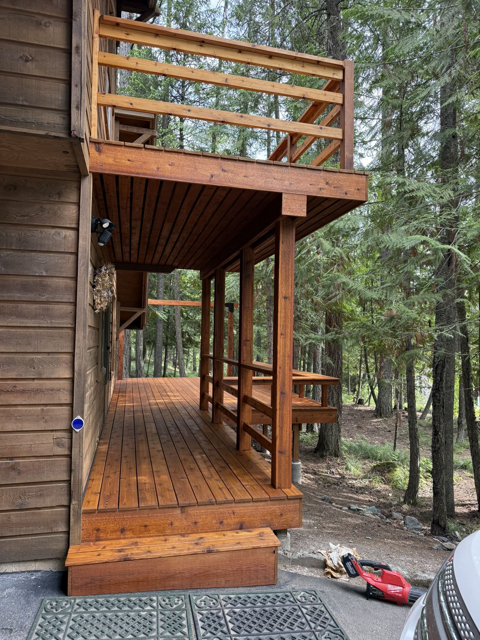 Elevated cedar deck with stair access on a wooded Montana lot