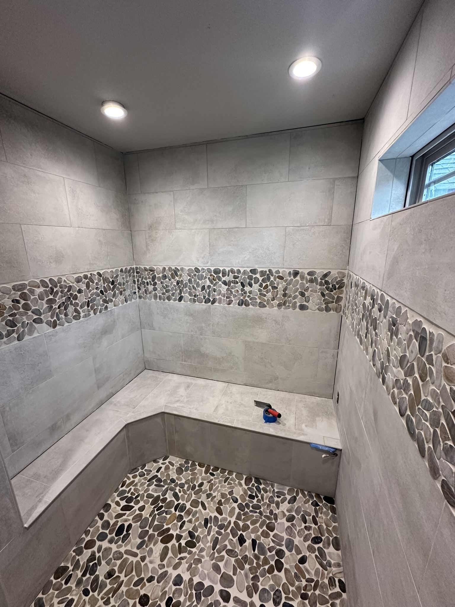 Curbless tile shower with river rock floor under construction